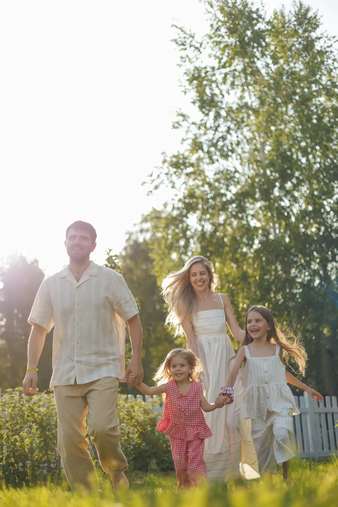 A happy family running together in a sunlit garden